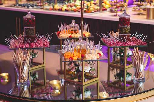 Beautifully decorated banquet catering table with variety of different food snacks, sandwiches, croissants and appetizers on a party event or celebration, delicatessen setting, coffee break set