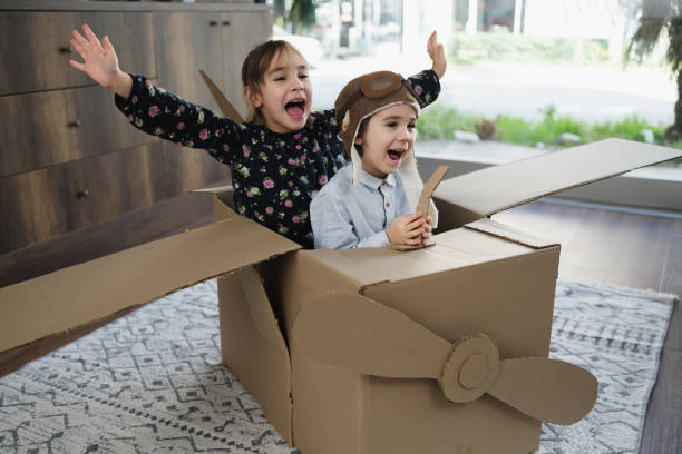 istock Children having fun playing with the plane from cardboard at home 1469339933