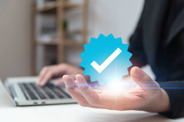 istock Businessman using laptop with verification account blue tick checkmark concept, verification account on social media platform, subscription status, eliminate bots, spam. 1469343787