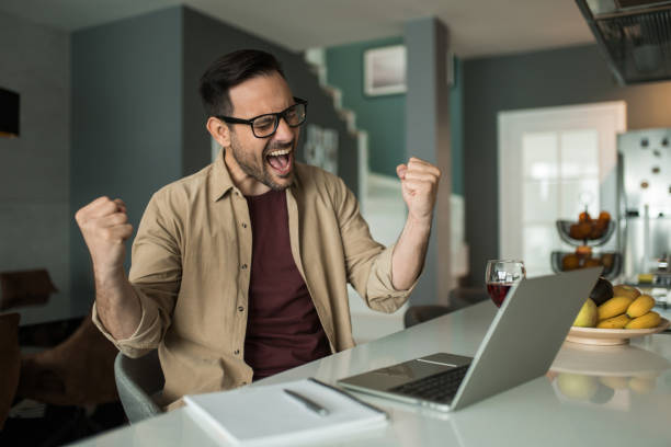 istock Ecstatic young businessman celebrating his achievement while working at home. 1469347105