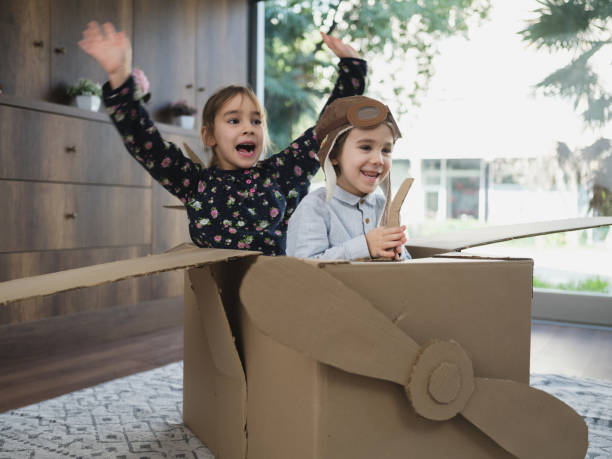 istock Children having fun playing with the plane from cardboard at home 1469347357