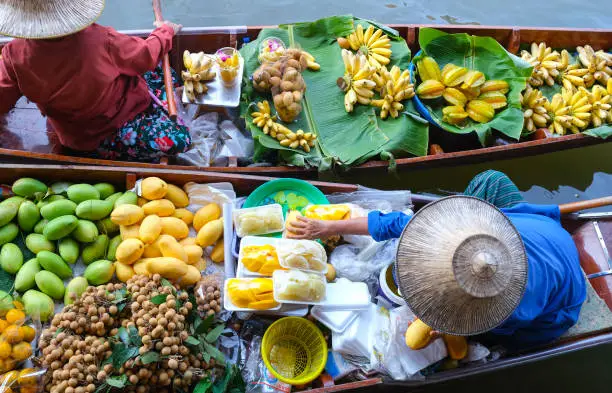 Photo of Famous Damnoen Saduak floating market in Thailand, Farmer goes to sell organic products, fruits, vegetables and Thai food, Ratchaburi province tourism concept. Thailand