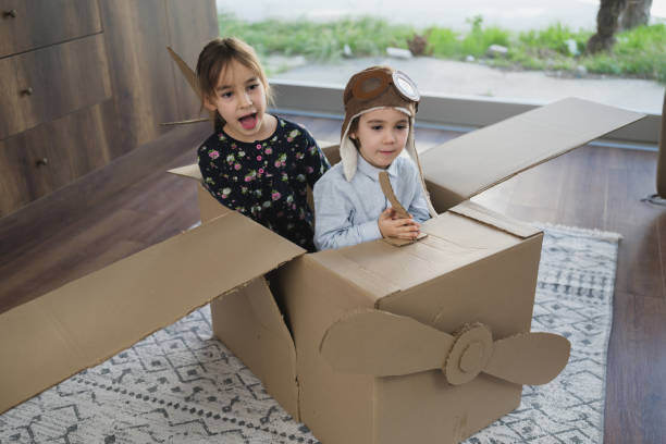 istock Children having fun playing with the plane from cardboard at home 1469351137