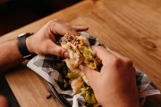 istock Burger - Man with watch on his wrist holding a hamburger in his hands 1469352419