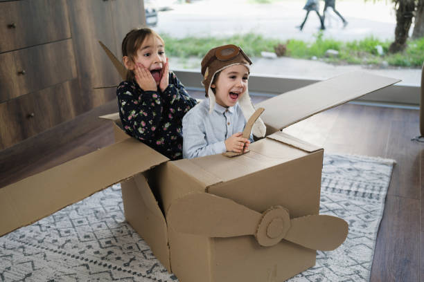 istock Children having fun playing with the plane from cardboard at home 1469353502