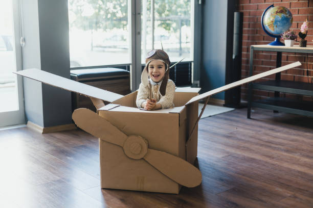 istock Little child boy having fun playing with the plane from cardboard at home 1469357849