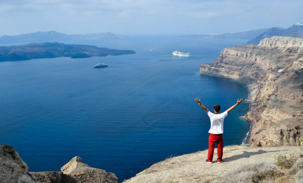 Santorini, Greece - Oct 10, 2018. An Asian young man enjoying at Oia Town in Santorini, Greece.