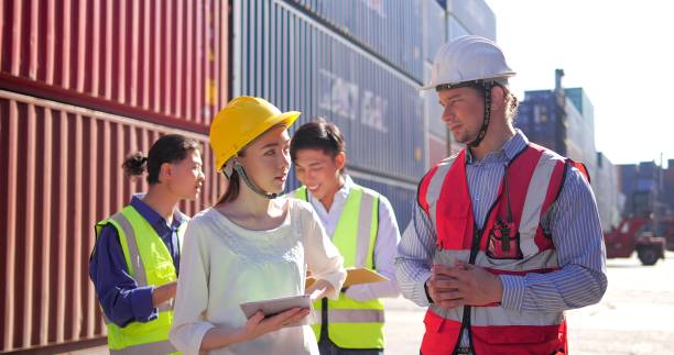 istock Group of engineer workers people wear safety hard helmet talking about working and problem at logistic cargo container yard 1469371448