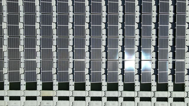 Aerial top view of solar panels or solar cells on buoy floating in lake sea or ocean.