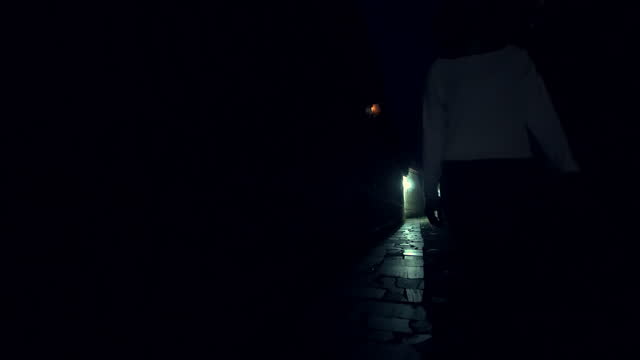 Mysterious woman walking in old alley dark street, noire atmosphere, investigating crime, detective concept