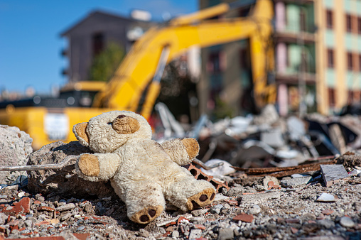 Camión excavador y el oso de peluche de un niño en el terremoto photo