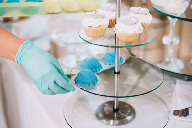 hands in gloves serves sweets. catering - cupcake cake birthday candy imagens e fotografias de stock