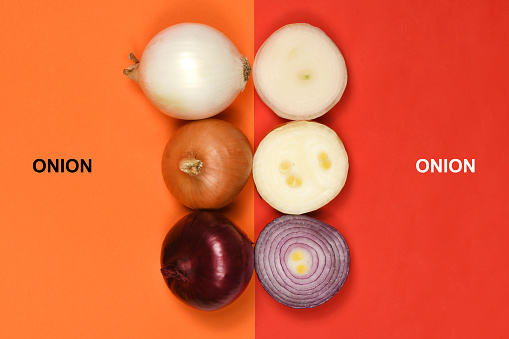Creative layout made of three onion bulbs of different colors (red, yellow and white). High resolution photo. Full depth of field.