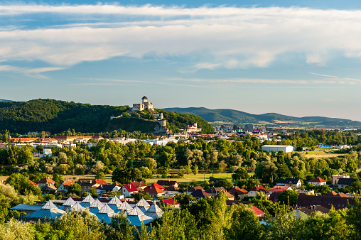 Panorama view of medieval newly restored Trencin castle over the Vah river with view of Trencin city in golden sunny summer day light in Slovakia. Trencinsky hrad above Trencin city.