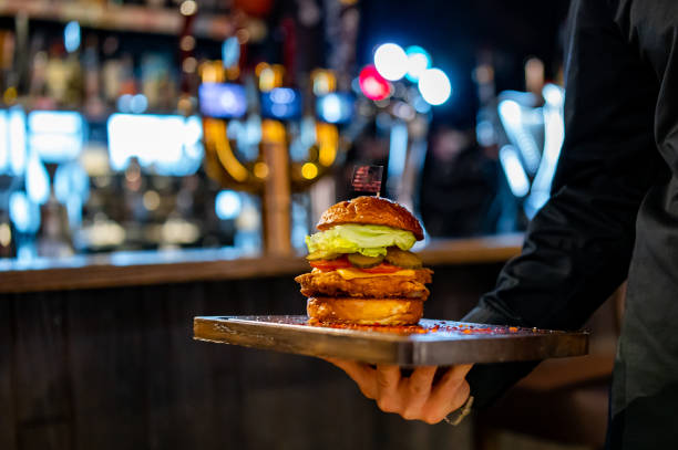 istock Men's waiter hands hold a tray with a cheeseburger in pub 1469434912