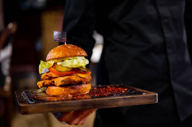istock Men's waiter hands hold a tray with a cheeseburger in pub 1469434913