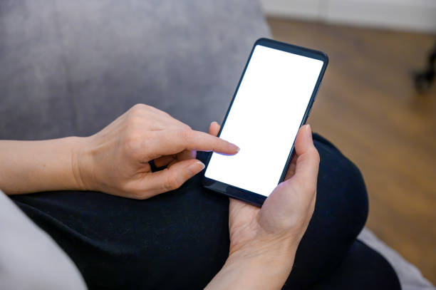 istock smartphone in hands. phone mockup in female hand showing white screen. 1469439230