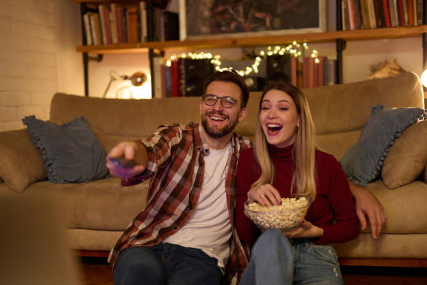 istock Young romantic couple watching TV at home 1469441831