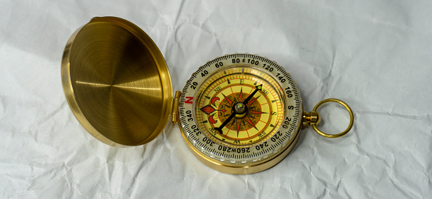 Retro styled golden compass Vintage still life. Sailing accessories. Travel, navigation, history, collecting, hobby