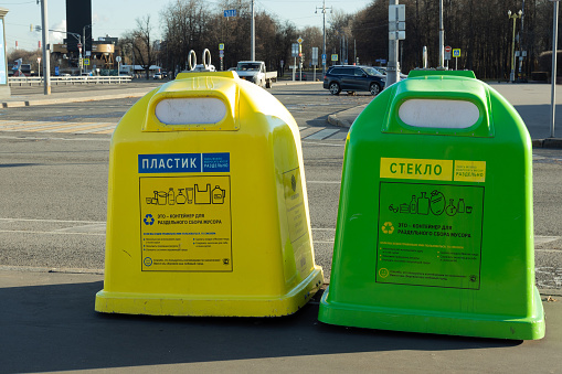 Moscow, Russia - November 14, 2022: Green and yellow litter bins for separate plastic and glass garbage in city.Recycling various types of recyclable trash.Caring for ecology.Environmental protection