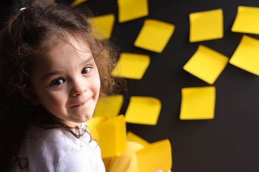 Little girl playing with sticky notes