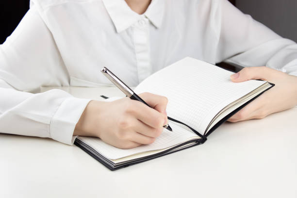 istock A young girl writes in a notebook.  At the white table 1469455425