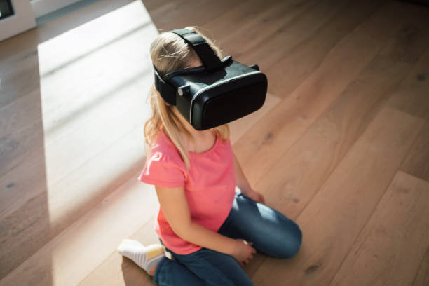 istock Female kid in a VR headset looking around the virtual world 1469456861