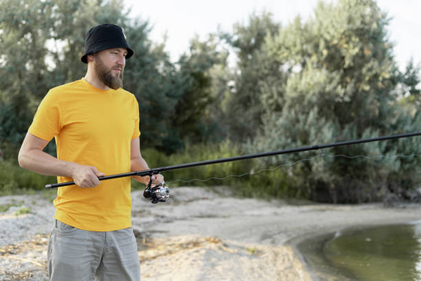 hombres pescando al atardecer y relajándose mientras disfrutan del hobby en verano - lure loc fotografías e imágenes de stock