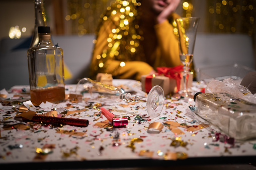 Messy table after party and sitting blurred man in background. Copy space