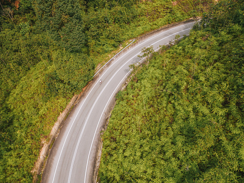 drone view Asian Chinese male cyclist enduring mountain road ascent in the morning