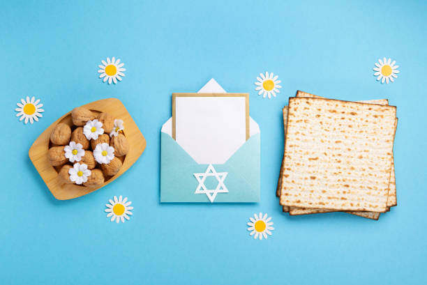 istock Passover Greeting Card with Matzah, Nuts and Spring Flowers on Blue Background. 1469464677