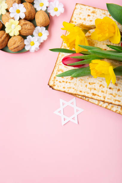 istock Passover Greeting Card with Matzah, Nuts and Spring Flowers on Pink Background. 1469464698