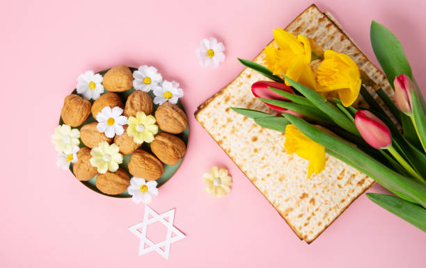 istock Passover Greeting Card with Matzah, Nuts and Spring Flowers on Pink Background. 1469464701