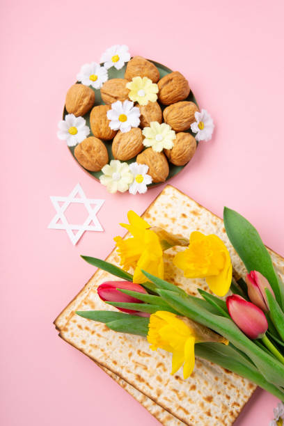 istock Passover Greeting Card with Matzah, Nuts and Spring Flowers on Pink Background. 1469464703