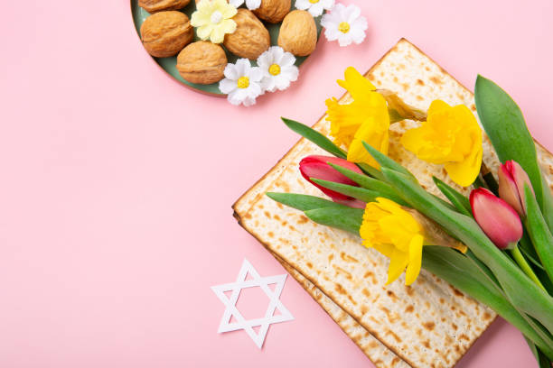 istock Passover Greeting Card with Matzah, Nuts and Spring Flowers on Pink Background. 1469464709