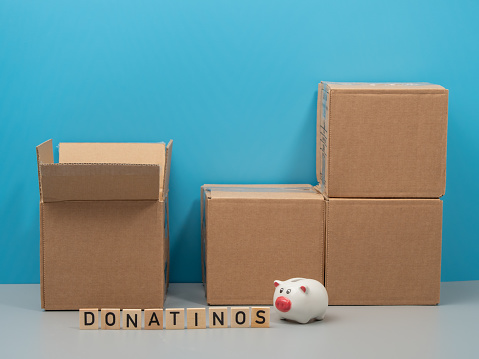 Humanitarian aid. Cardboard boxes with donations on a blue background. Close-up.