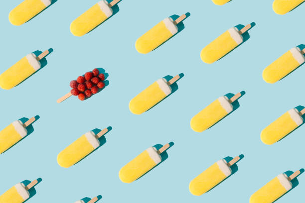 istock Yellow ice cream bars and raspberries on pastel blue background. Flat lay pattern. 1469468559