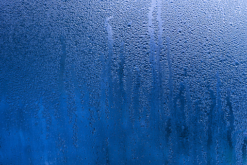 Glass wall of shower at bathroom with water drops and natural light in black and white. Photo taken August 5th, 2023, Zurich, Switzerland.