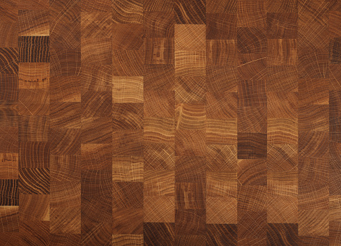 Brown oak wooden butcher chopping block, natural durable end grain hard wood cutting board texture background pattern, close up
