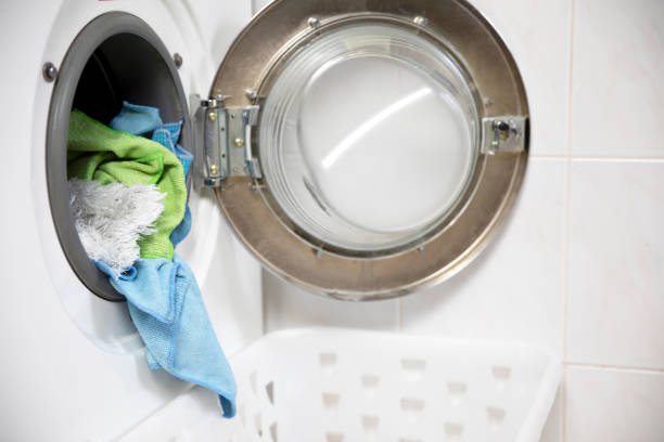 istock Laundry concept. white and modern washing machine with open door standing inside bright apartment or house light interior close up 1469480181