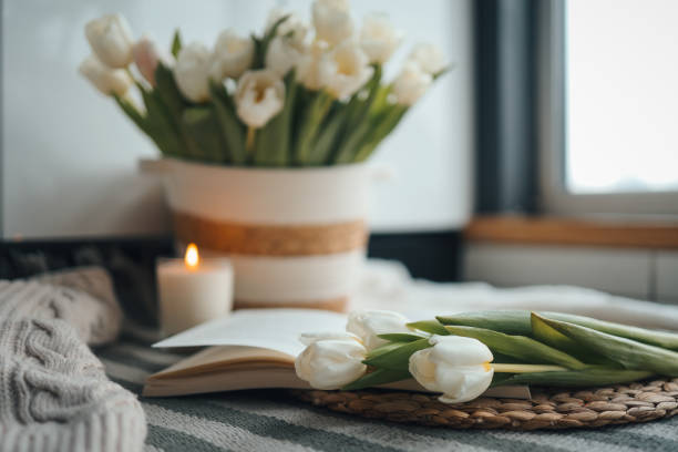 istock Open book, candle and basket with tulips, spring cozy composition in home interior 1469481558