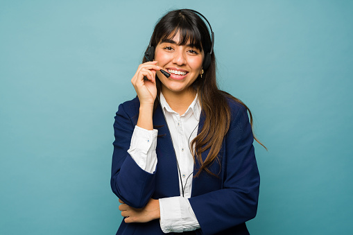 Cheerful customer service representative wearing a headset while feeling happy working at a call center