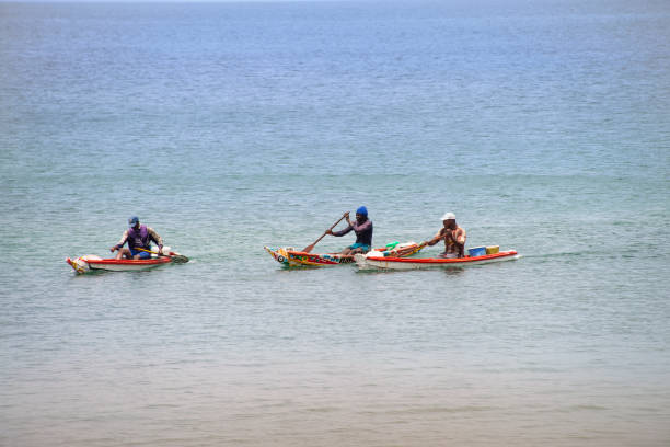 trzech rybaków. niezidentyfikowani mężczyźni w swoich pirogach (afrykańskich łodziach rybackich), wracający z połowów - rowboat fishing africa fishing industry zdjęcia i obrazy z banku zdjęć