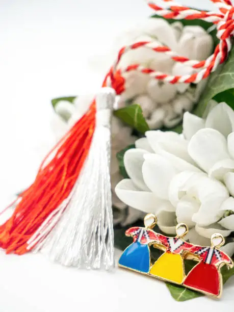 bouquet of snowdrops and red white strings and tricolor brooch on white background, 1st of March holiday, Martisor