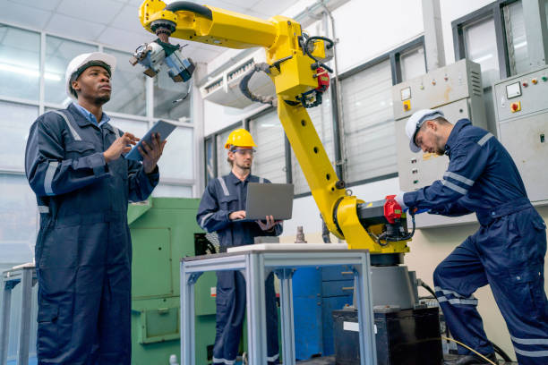 istock African American technician work with his team to check and maintenance robotic arm in factory workplace. 1469487362
