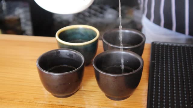 Pour hot water into a black ceramic mug