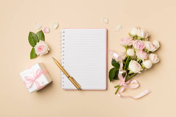 istock Notebook, gift box and rose flowers on color background, top view 1469493116