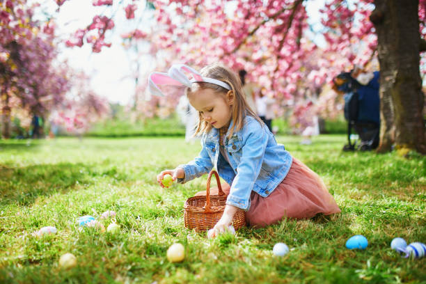 Vorschulkind mit Hasenohren spielt Eiersuche an Ostern – Foto