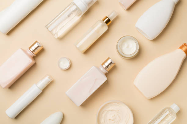 istock Different cosmetic bottles and container on color background, top view 1469493714