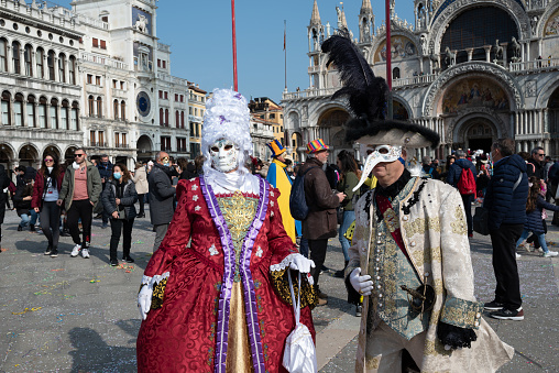 Venice, Italy - February 17, 2023: Colorful carnival masks pose for people at a traditional festival in Venice, Italy.